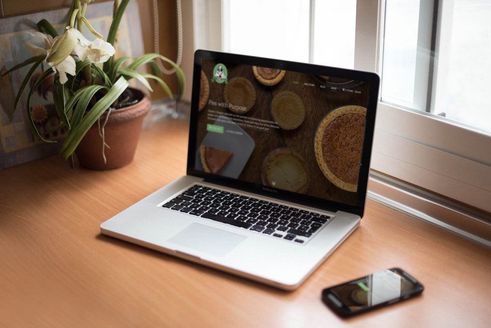 A picture of a macbook and a small phone with the Darden's Delights website on it.