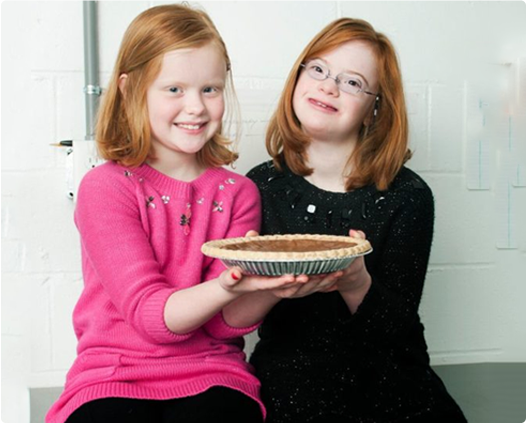 Darden and Darden's sister holding a pie between them