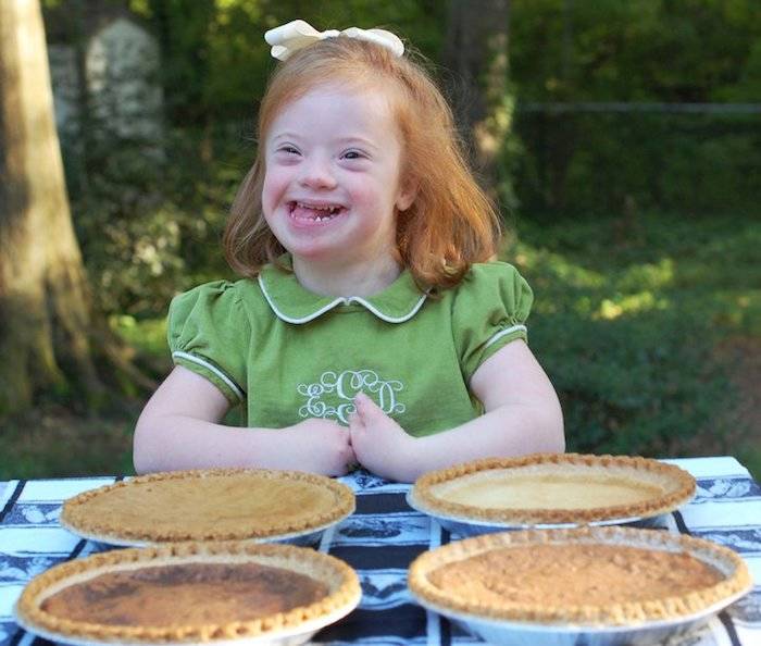 Darden smiling with pies on table in front of her.
